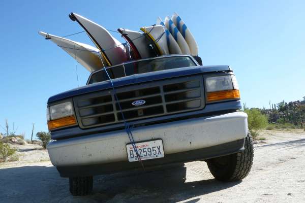 four sea kayaks and three SUPs on truck