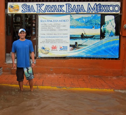 Ramon stands ankle deep in rain outside the Sea Kayak Baja Mexico retail store in Loreto, BCS